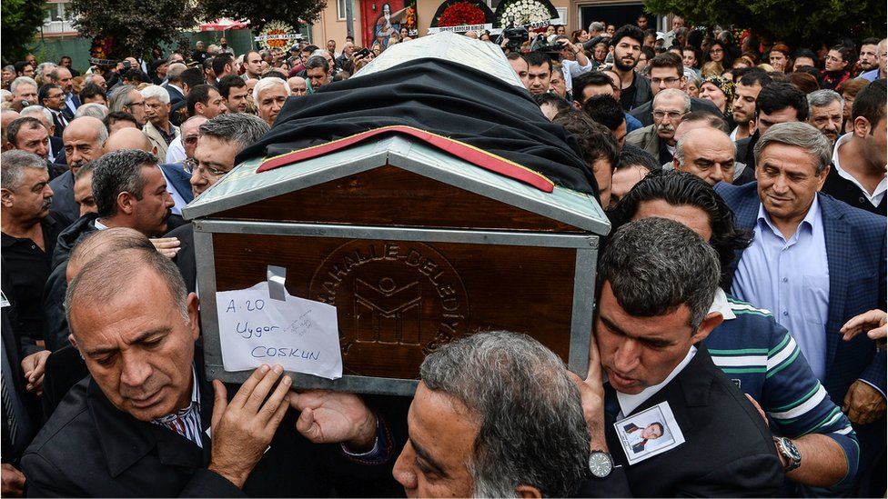 mourners carry the coffin of 32 years old lawyer Uygar Coskun, killed in Saturday"s bombing attacks