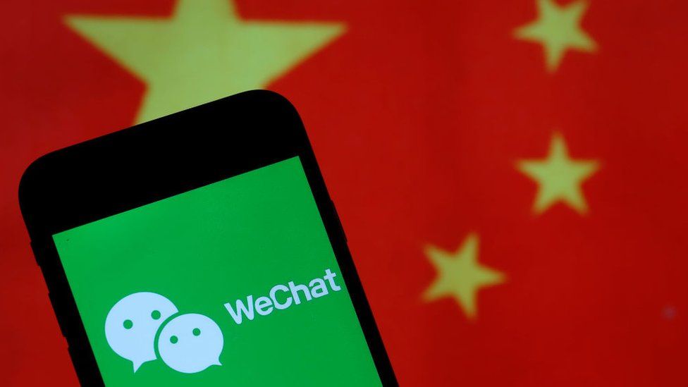 In this photo illustration the logo of Chinese media app for creating and sharing short videos WeChat is displayed on the screen of a smartphone in front of a Chinese flag