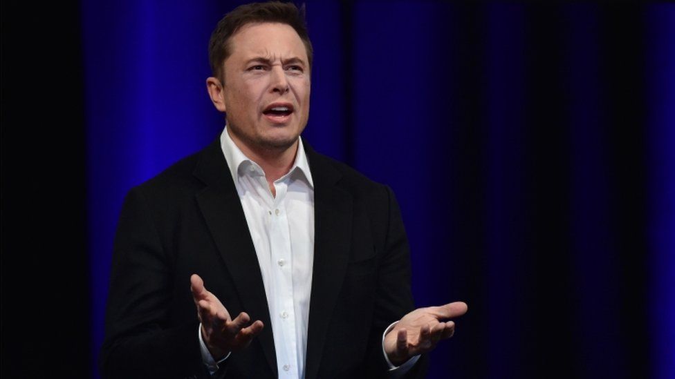 Elon Musk looks annoyed and gesticulates with his hands