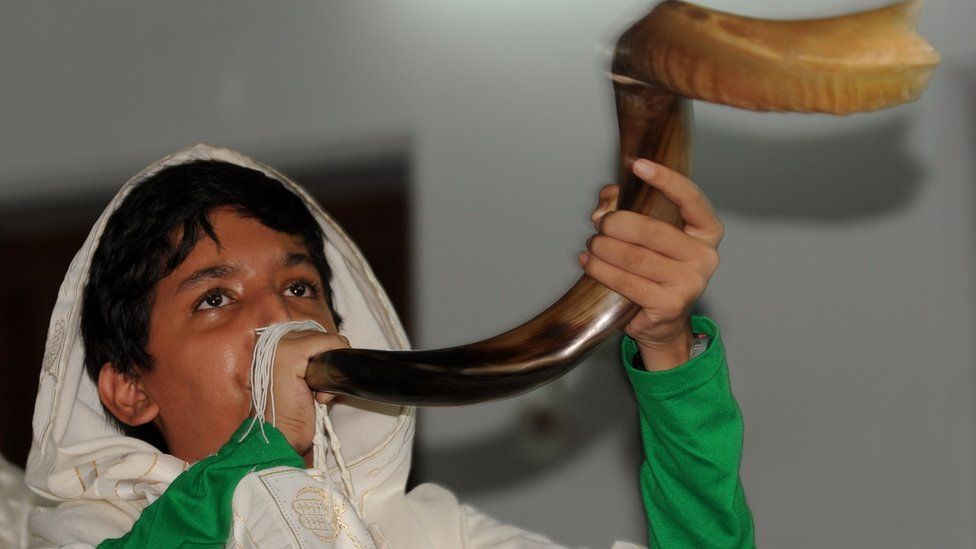 A Jewish Indian boy blows the 'Shofar' horn to gather devotees around the Torah at the Magen Abraham Synagogue in Ahmedabad on September 9, 2010, on Jewish New Year Rosh Hashana. Synagogue President Benjamin Reuben numbered the Jewish community in Ahmedabad at 130, with an approximate total of 4,500 members in India whereof the majority, approximately 4,000, live in the financial capital Mumbai.