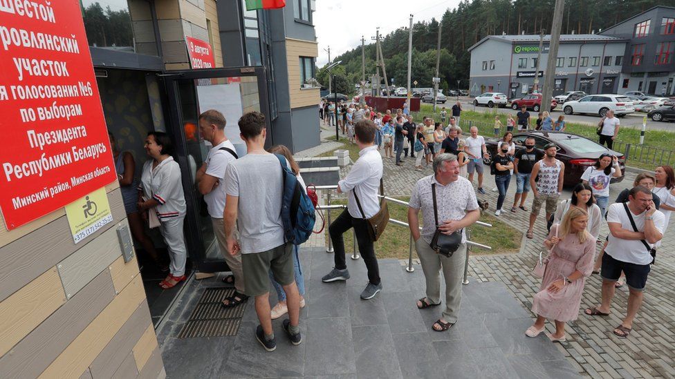 People queue outside a polling station to cast their votes in the presidential election in Barauliany Belarus, August 9, 2020.