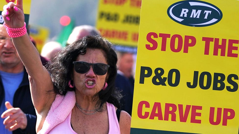 A woman at a protest in Dover holds a placard reading: "Stop the P&O jobs carve up"