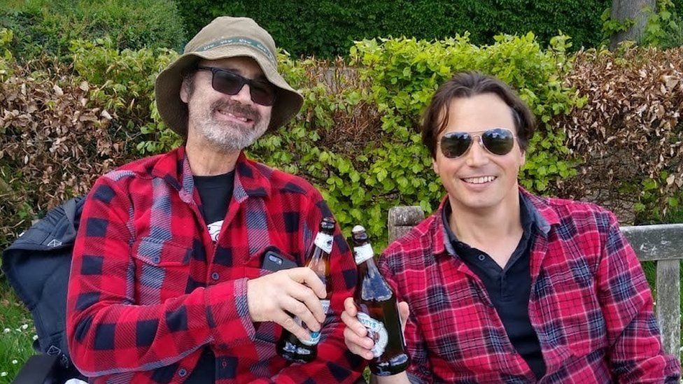 Alexis Leventis (left) and Paul Taylor each holding a beer