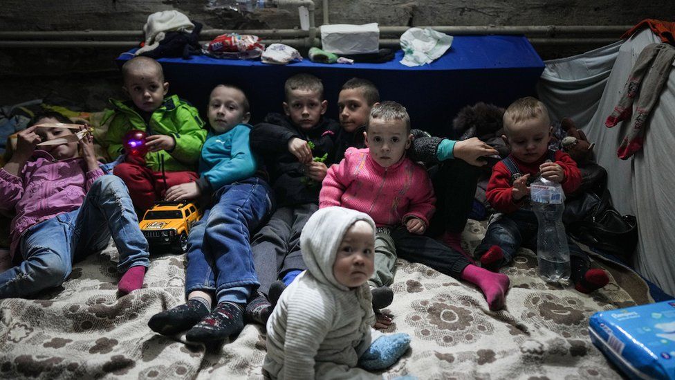 Children sitting huddled in a bomb shelter