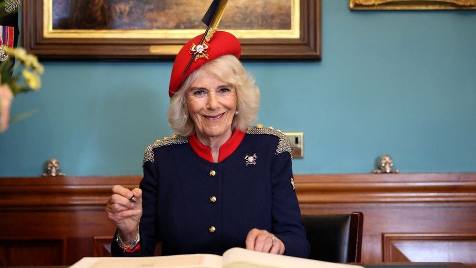 Queen Camilla signs the visitor book