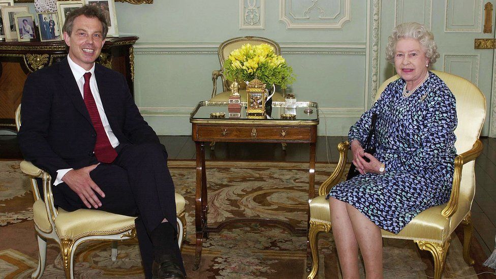 Tony Blair sits alongside Queen Elizabeth II in Buckingham Palace