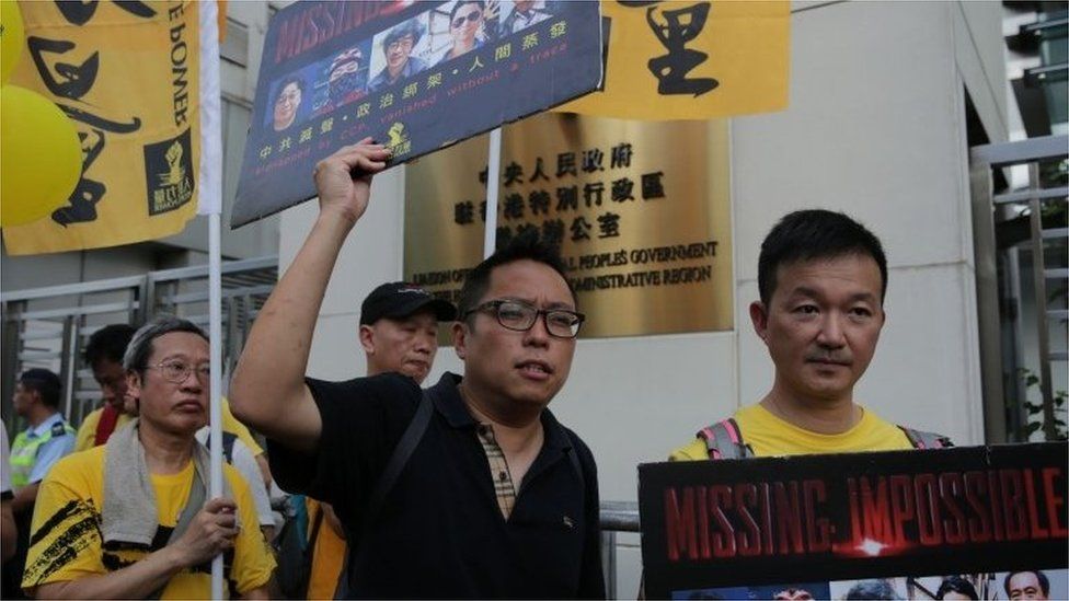 Protesters hold placards outside the Chinese Liaison Office in support of Lam Wing-kee, one of five Hong Kong booksellers who went missing last year, during a rally in Hong Kong (18 June 2016)