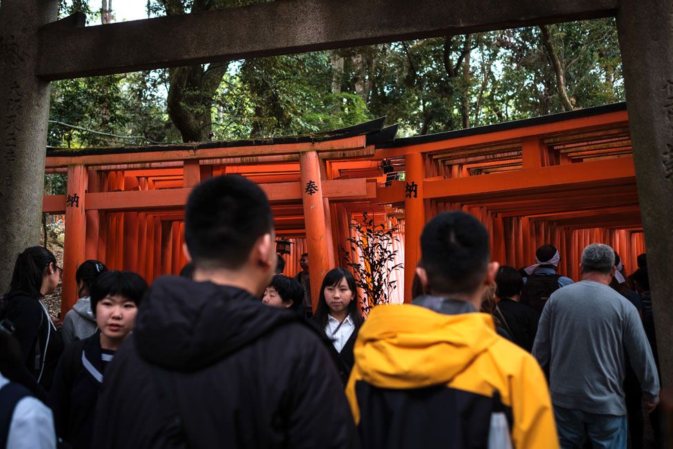 A crowd of tourists wait to access famous Torii path at Fushimi Inari taisha in Kyoto. 29 April 2019