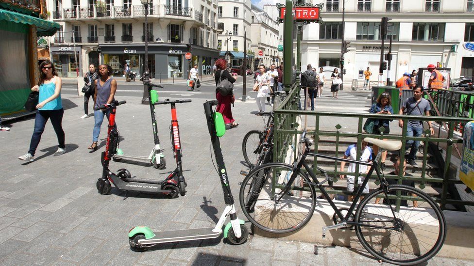 Местные жители проходят мимо электросамокатов, припаркованных на улице у станции метро Saint Paul в Ле-Маре в Париже, Франция, 17 июня 2019 г.