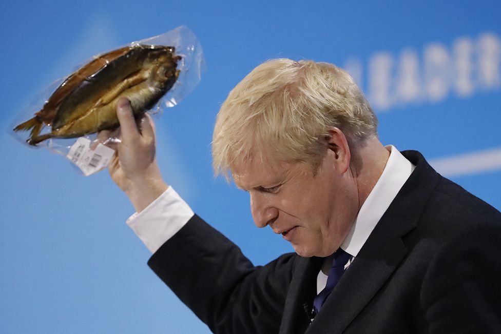 Conservative MP and leadership contender Boris Johnson holds up kipper fish in plastic packaging as he speaks at the final Conservative Party leadership election hustings in London, on July 17, 2019