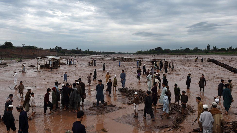 Locals gather on a flooded plain