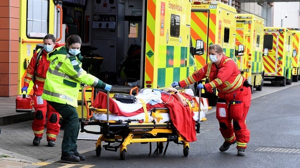 Ambulance workers assist a patient outside the Royal London Hospital in London