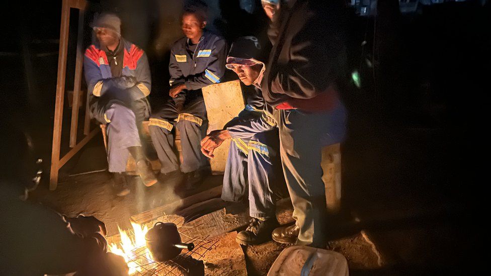 Men wait for the power to return in Zimbabwe