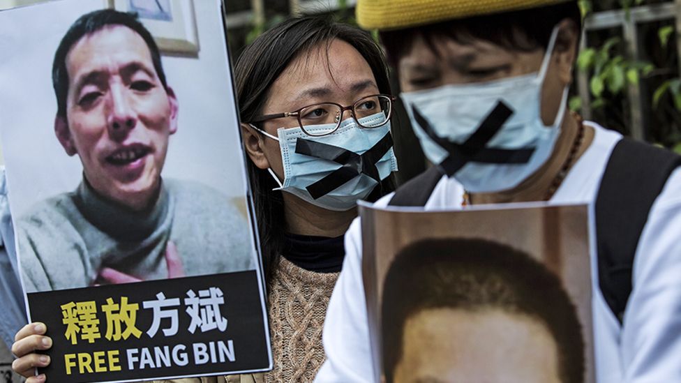 An activist holds a placard of missing citizen journalist Fang Bin, as she protests outside the Chinese liaison office in Hong Kong in 2020