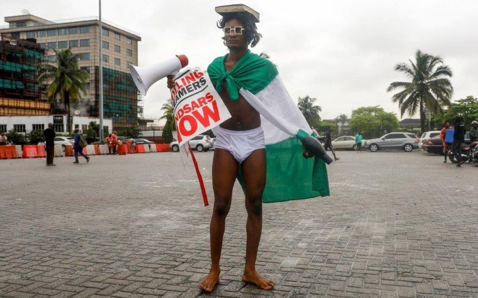 A demonstrator in underwear carries a hairdryer and a megaphone during a protest over alleged police brutality, in Lagos, Nigeria October 14, 2020.