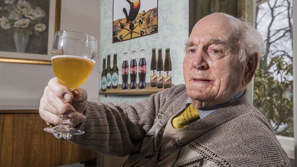 Care home resident enjoying a beer