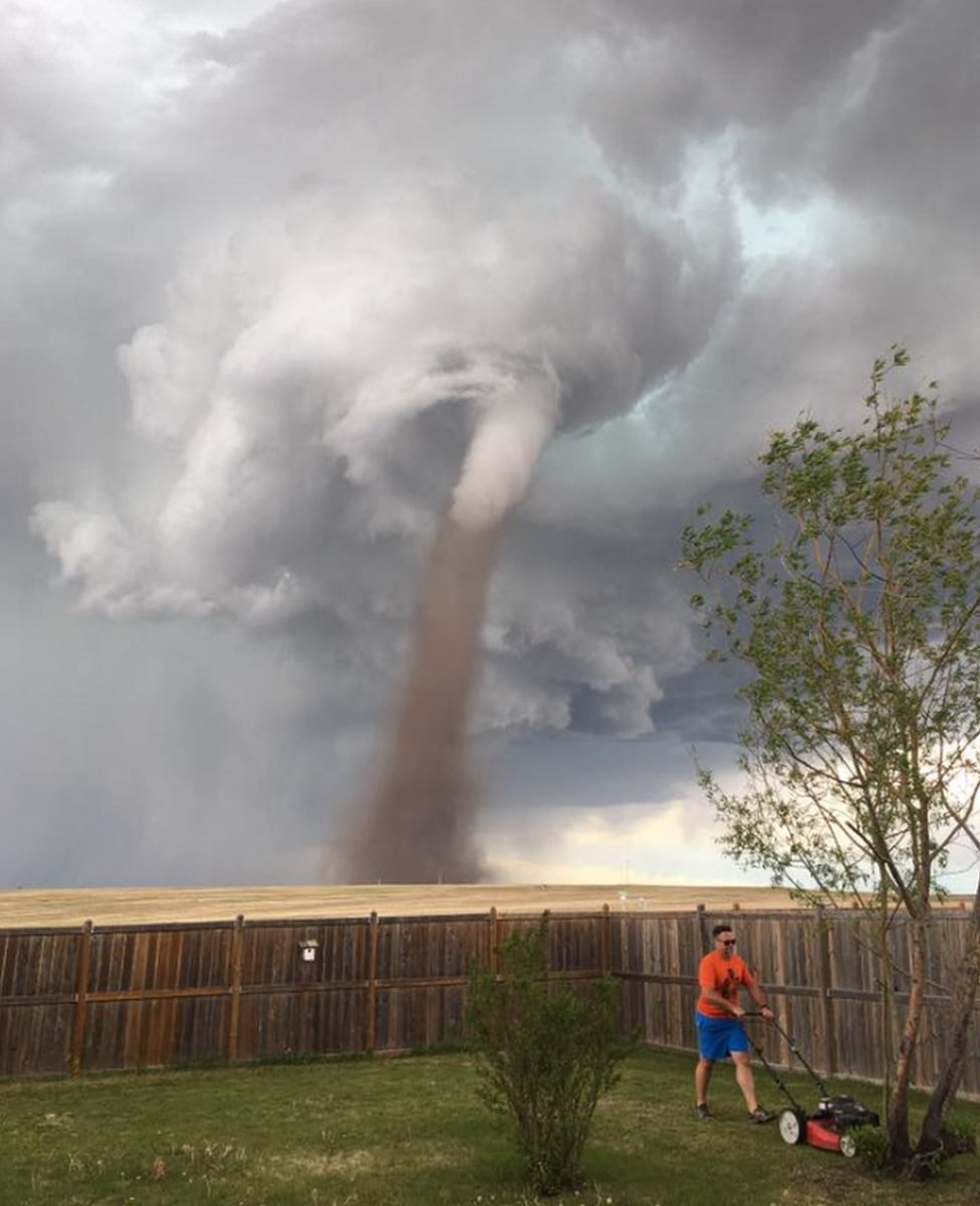 Cecilia Wessels' photo of her husband Theunis mowing a lawn with a tornado behind him