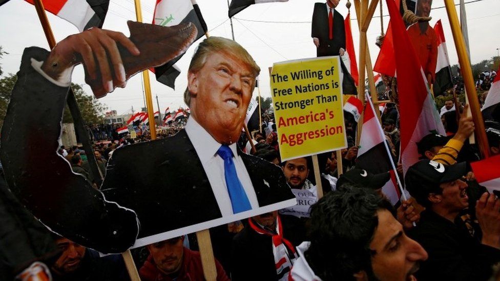 Supporters of Iraqi Shia cleric Moqtada al-Sadr carry placards depicting Donald Trump