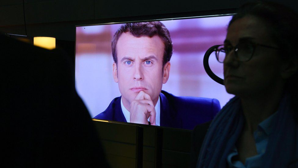 Emmanuel Macron is pictured on a television screen backstage, seconds before the start of the live debate broadcast