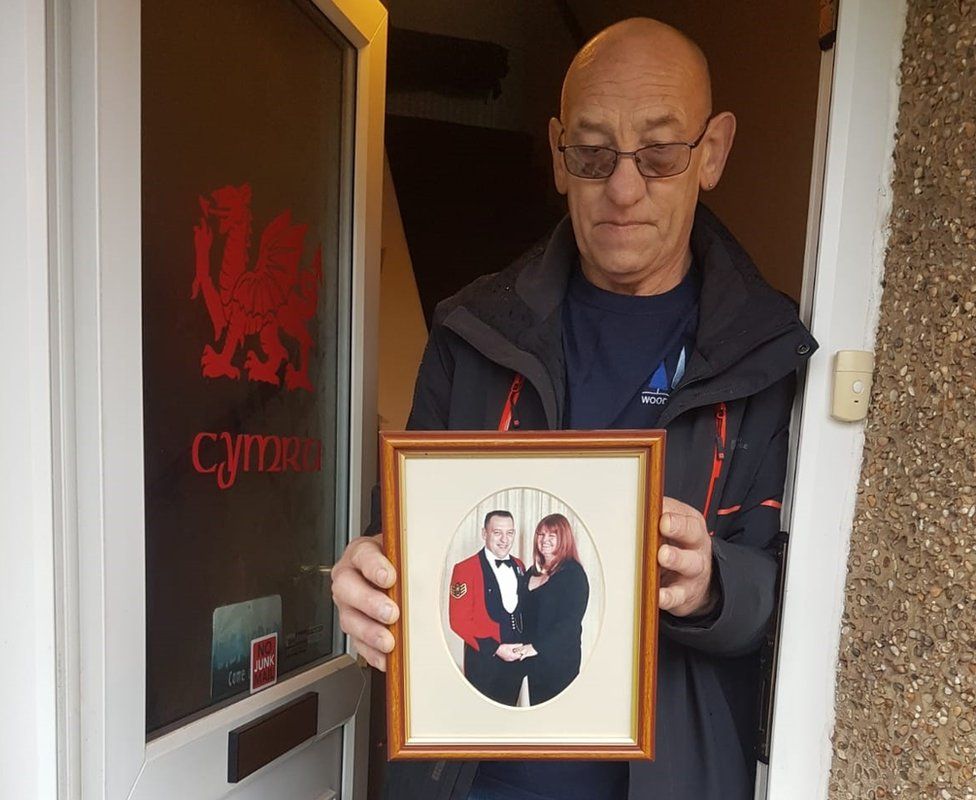 Tony Price, holding a photograph of him and his wife Tina, who he cares for