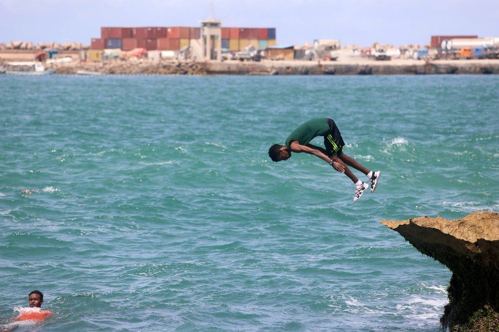 A boy jumps into the water at Lido beach, Mogadishu, Somalia - Friday 18 June 2021
