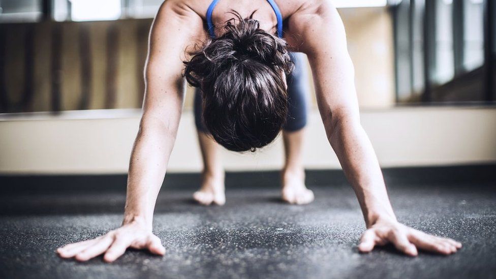 A woman in a downward-dog yoga position