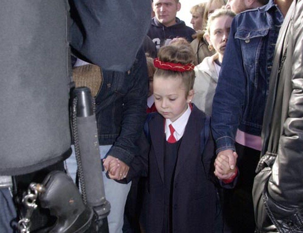 Children held hands tightly with family members as they passed police and Army lines
