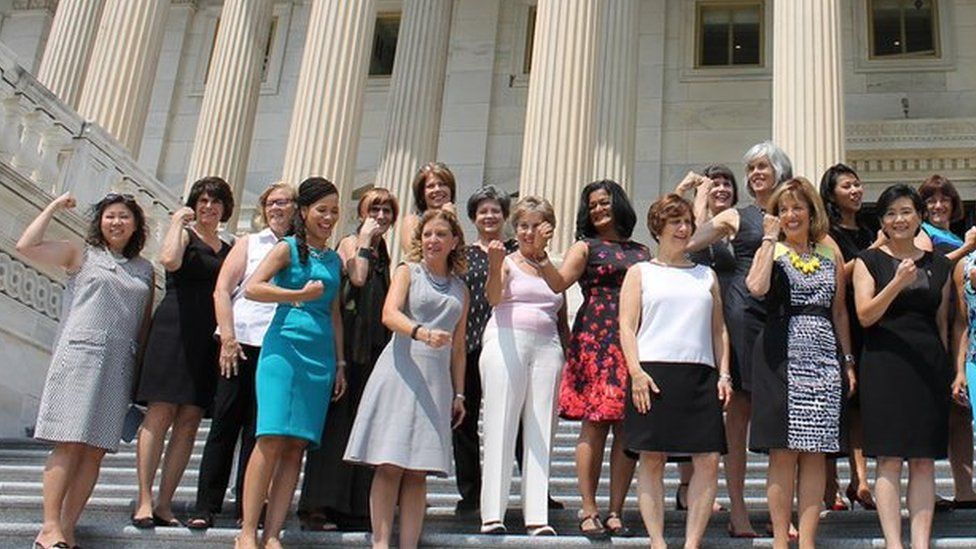 Women gather on the steps of Congress on Friday wearing outfits with no sleeves