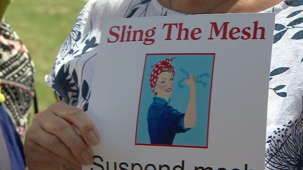 A woman holding a poster that reads: Sling the mesh
