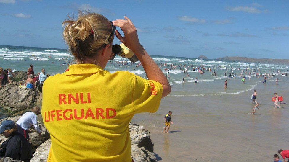 RNLI lifeguard on busy beach