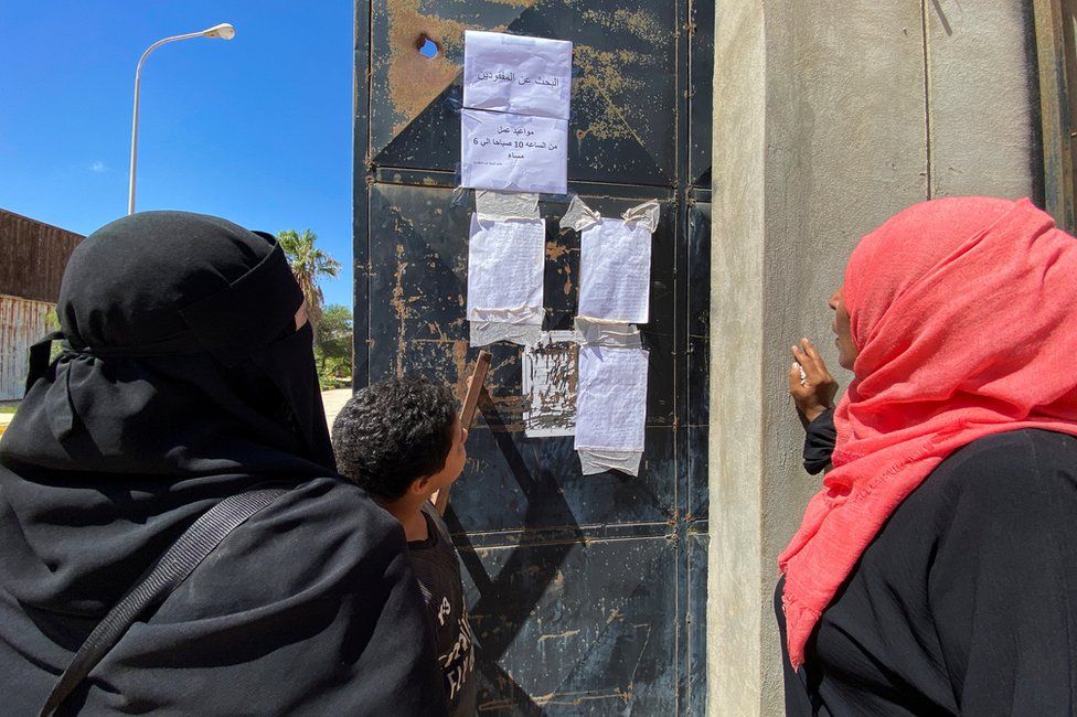 People look missing notices in the aftermath of the floods in Derna.