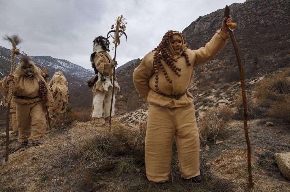 Revellers dressed as Harramachos walk in the mountain.