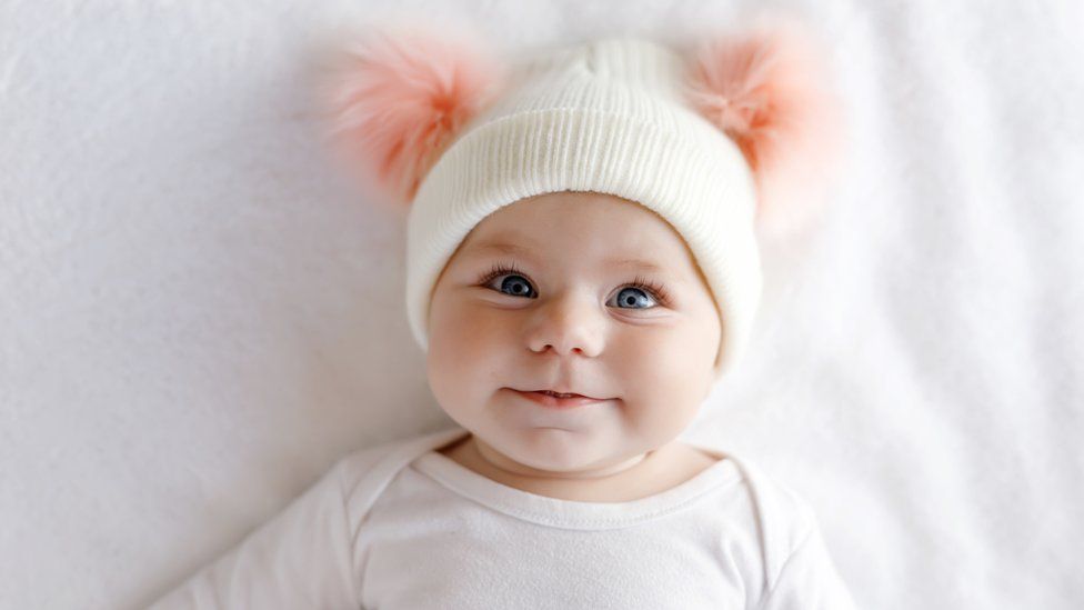 A cute baby wearing a bobble hat