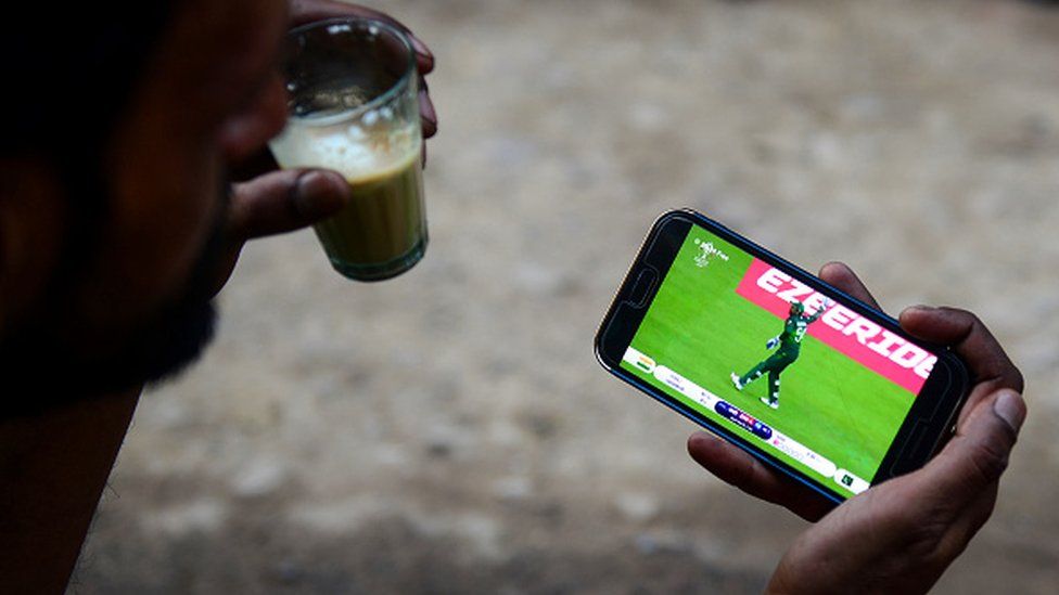 Индийский болельщик смотрит прямую трансляцию матча чемпионата мира по крикету между Индией и Пакистаном по мобильному телефону в Аллахабаде, 16 июня 2019 г.