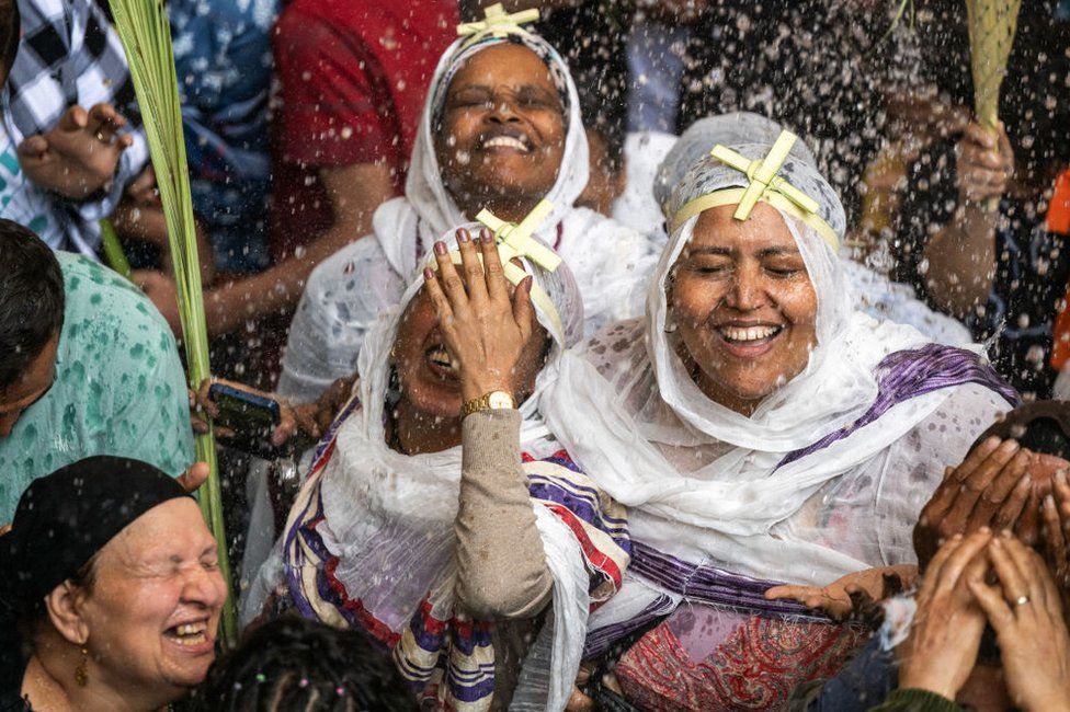 Ethiopian and Egyptian Christian worshippers are sprinkled with holy water during the Palm Sunday service.