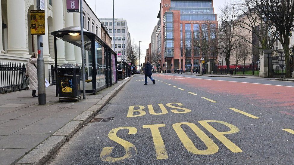 Bus stop and lane empty with pedestrians