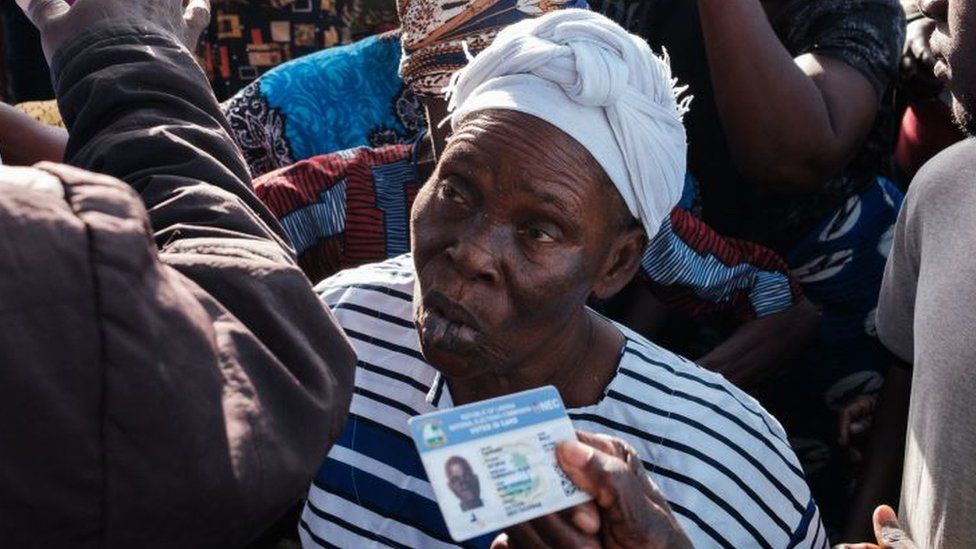 People queue to have their identity documents checked before going into a voting station in Kenny Town, Monrovia on October 10, 2023