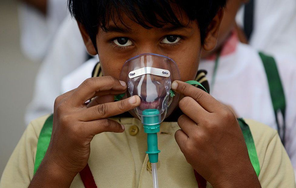 An Indian schoolchild adjusts his facemask before the start of an event to spread awareness of the problem of air pollution in New Delhi on June 4, 2015, on the eve of World Environment Day.