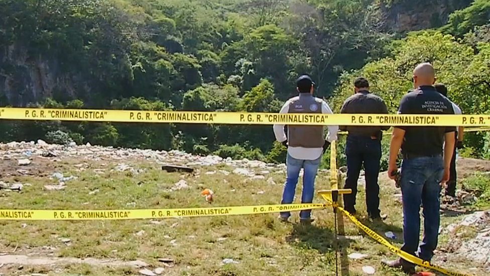 A view of the dump with crime scene tape and police officers standing by
