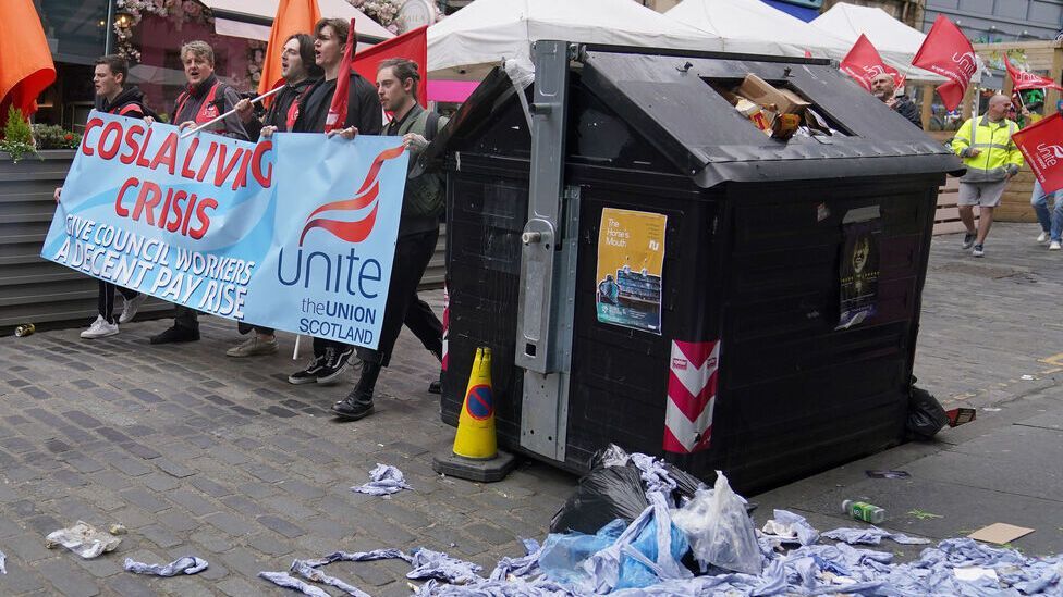 workers on strike in near to full bin in edinburgh