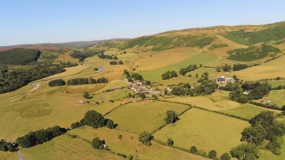 Aerial view of Upper Coquetdale showing hills, fields, trees and hedges and 