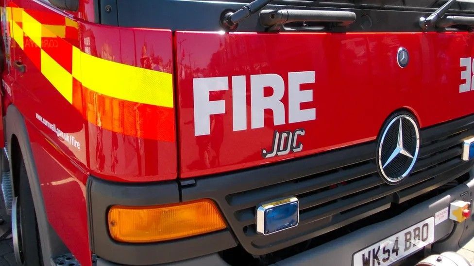 The front of a red fire engine with the word fire in white