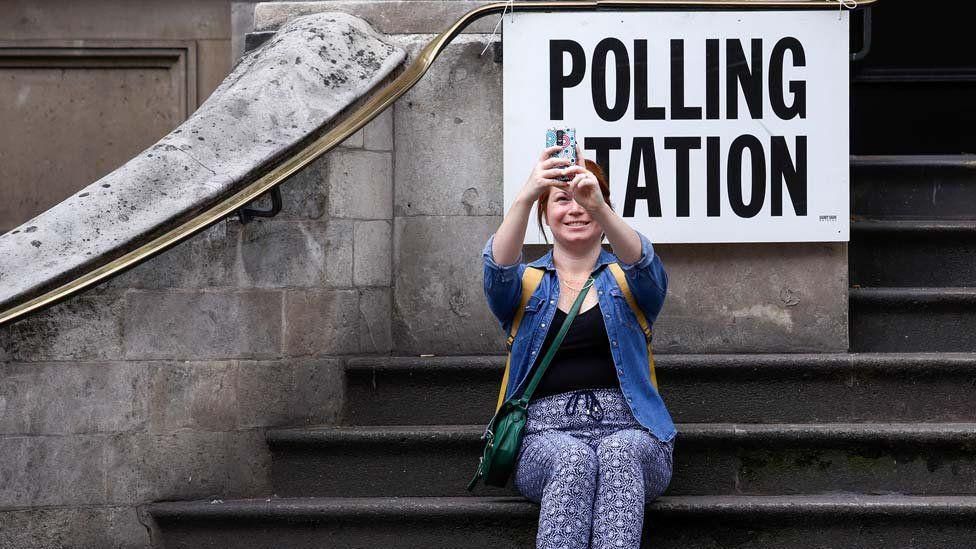 Woman takes a selfie photo outside a polling station