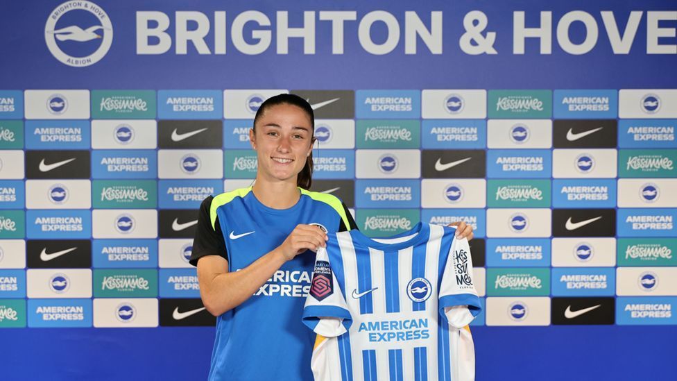 Bruna Vilamala memegang kaus Brighton