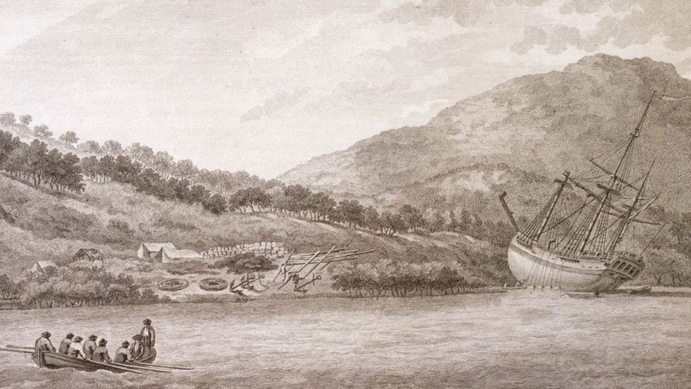 A line drawing of the wooden sailing ship HMB Endeavour in front of the Australian shoreline with a manned rowing boat in the foreground and a camp on land in the background 