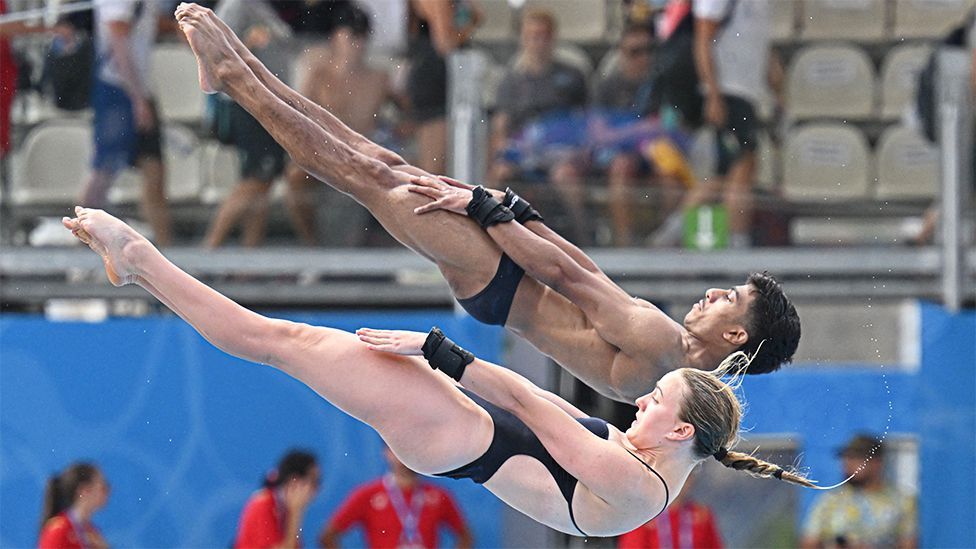 Kyle Kothari and Lois Toulson in a synchronised diving pose, compete during the Diving Mixed Synchronised Platform final event