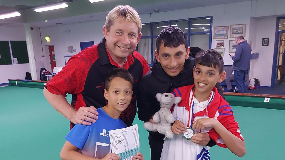 Thomas and his brothers with the patron of Disability Bowls England, Greg Harlow