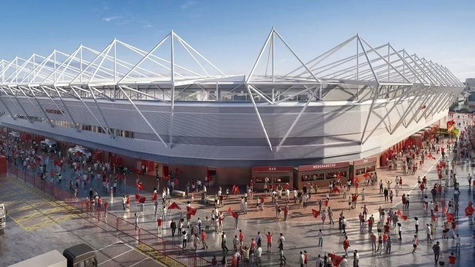 A cgi image of the St Mary's football stadium. The stadium is buily from a lower layer of brick and white metal above. There are a series of kiosks around the stadium. Along two sides fans are gathered with some carrying large red flags.