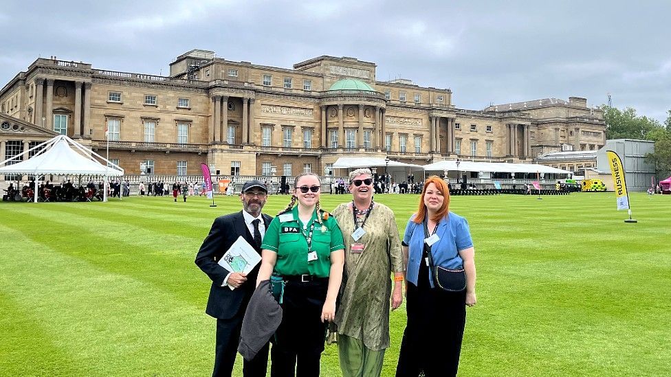 Hafwen Clarke on the lawn at Buckingham Palace alongside three other people