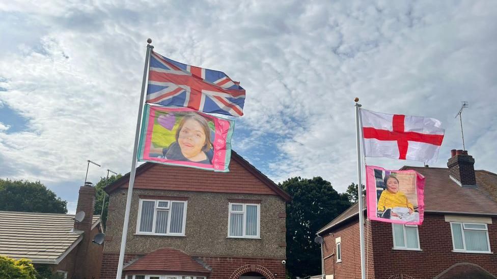 Flags with Erin's face outside a home. 